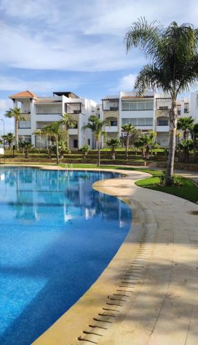 a swimming pool in front of a building at Chez Charifa in Asilah