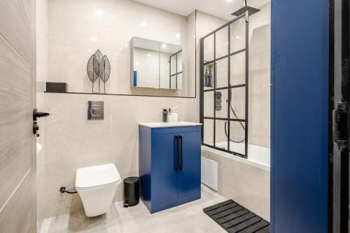 a bathroom with a toilet and a sink and a mirror at Luxury Apartment Close to Elstree & Borehamwood Station in Borehamwood