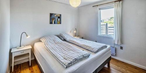 a bedroom with a bed and a window at VE072-Vejers-Strand-Violvej-9 in Vejers Strand