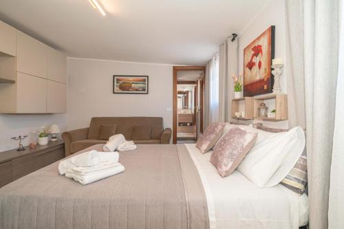 a bedroom with a large bed with towels on it at Hedoné apartment in Schisò