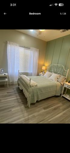 a bedroom with a bed and a window with curtains at The Casita at Riverwalk in Bakersfield