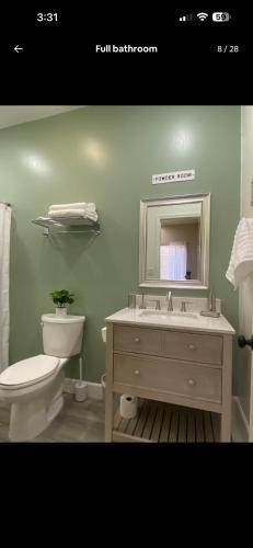 a bathroom with a toilet and a sink and a mirror at The Casita at Riverwalk in Bakersfield