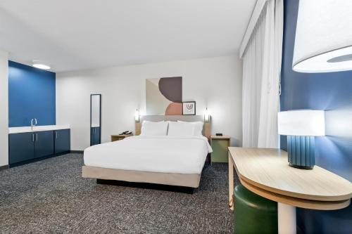 a hotel room with a bed and a desk at Spark By Hilton Redlands in Redlands
