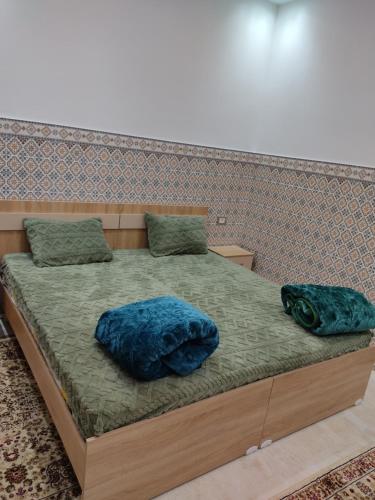 a bed with two pillows on top of it at اقامة يوسف اللكراء in Gabès