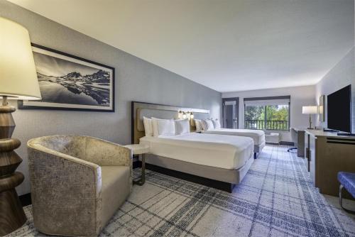 a hotel room with two beds and a chair at The Newberry Hotel Bend, Tapestry Collection by Hilton in Bend