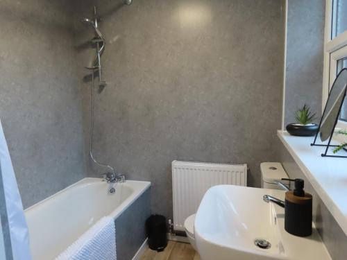 a bathroom with a sink and a tub and a toilet at Portman House in Middlesbrough