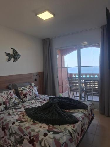 a bedroom with a bed with a view of a balcony at Paraíso Jandia beach in Costa Calma