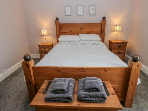 a bedroom with a wooden bed with towels on a table at 49 Waddington Road in Clitheroe