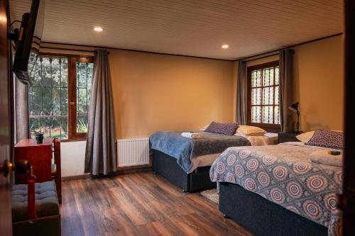 a bedroom with two beds and two windows at Finca Agrreste in Nemocón