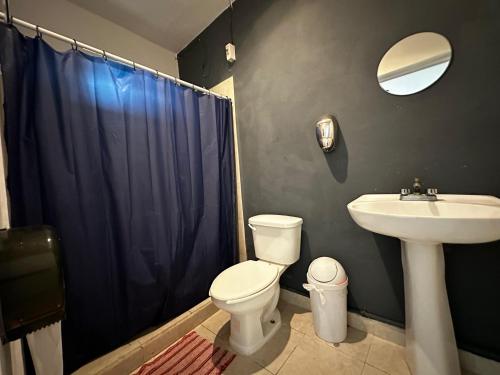 a bathroom with a white toilet and a sink at The Soul Hostal in Playa del Carmen
