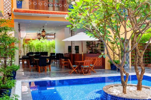 a restaurant with a table and chairs next to a pool at House Boutique Eco Hotel in Phnom Penh