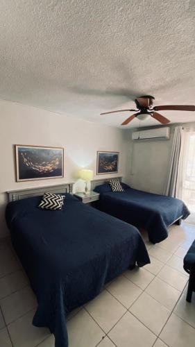 a bedroom with two beds and a ceiling fan at Mision del Sol 302 in Bahía Kino
