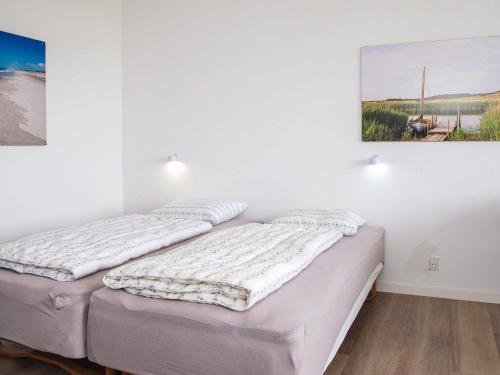 two beds in a room with a painting on the wall at Apartment with shared kitchen in Vedersø in Ulfborg
