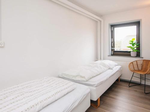 a white bedroom with two beds and a window at Apartment in Holiday park- free waterpark in Ulfborg