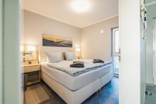 a white bedroom with a bed and a desk at Ferienwohnung Boddentraum in Zingst
