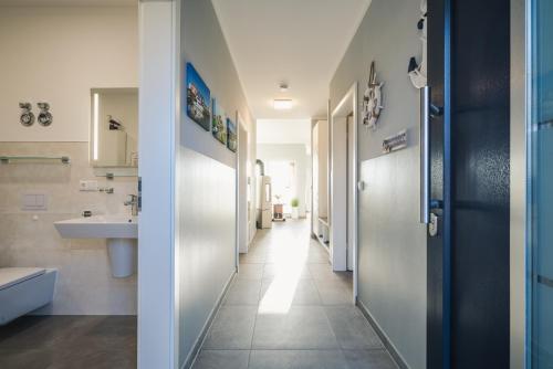 a hallway of a bathroom with a sink and a toilet at Ferienwohnung Boddentraum in Zingst
