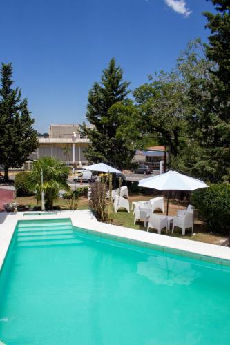 a swimming pool with chairs and umbrellas at Hotel Terrazas by CPH in Villa Carlos Paz