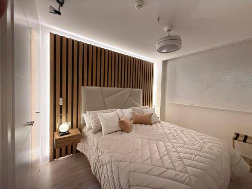a bedroom with a large bed with a white comforter at Apartamento Blois Deluxe in Rivas-Vaciamadrid