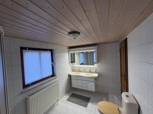 a white bathroom with a sink and a window at Bergliebe in Weitnau