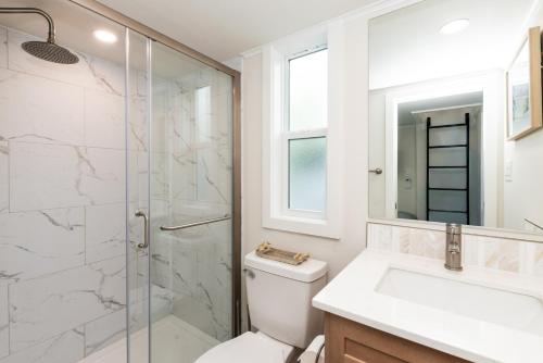 a bathroom with a shower and a toilet and a sink at Pool • Fire Pit • Amenities • Sleeps 8 in Swain