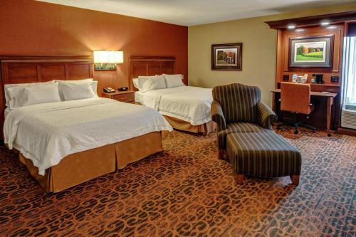 a hotel room with two beds and a chair at Hampton Inn Winchester KY in Winchester