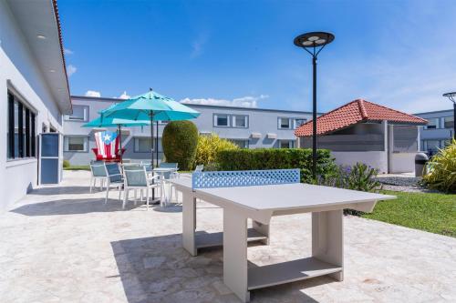 a table and chairs and an umbrella on a patio at Spark by Hilton Ponce in Ponce