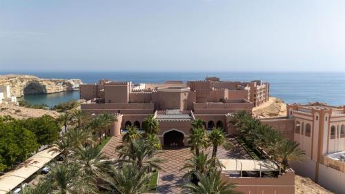 a view of a building with the ocean in the background at Al Husn Hotel Muscat - managed by Hilton in Muscat