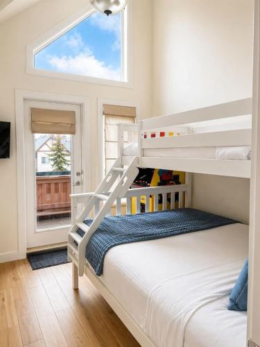 a bedroom with a bunk bed and a window at Alpine Hideaway at Alpine Village in Canmore