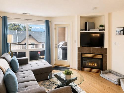 a living room with a couch and a fireplace at Alpine Hideaway at Alpine Village in Canmore