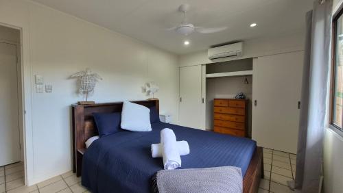 a bedroom with a blue bed with white pillows at Stay on Sooning in Nelly Bay