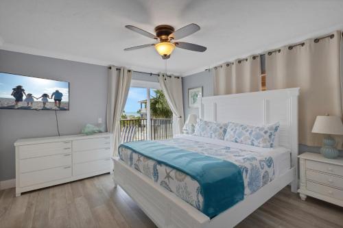 a bedroom with a bed and a ceiling fan at Oceanview - Steps to Beach - King Suite - Pool - Arcade in Clearwater Beach