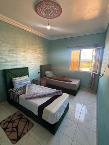 a bedroom with two beds and a ceiling at Classico Apartments in Tan-Tan Plage