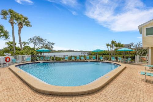 a large swimming pool with chairs and umbrellas at Oceanview - Steps to Beach - King Suite - Pool - Arcade in Clearwater Beach