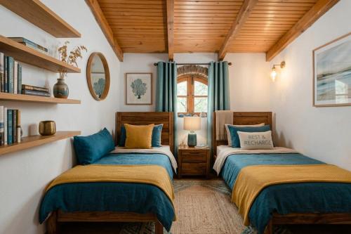 two beds in a room with wooden ceilings at Casa Da Maria - Villa with Private Pool and Barbecue in Fonte do Bispo