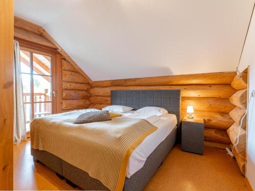 a bedroom with a large bed in a room with wooden walls at Janna in Mauterndorf