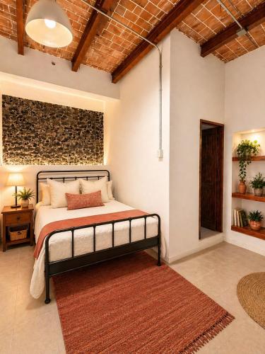 a bedroom with a bed and a brick wall at Morada Luna Centro Histórico in Mexico City