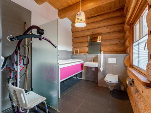a bathroom in a log cabin with a pink sink at Janna in Mauterndorf