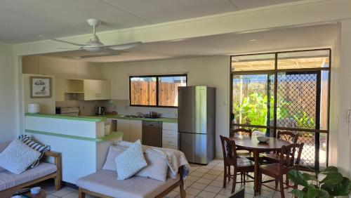 a kitchen and dining room with a table and a kitchen and a dining room at Stay on Sooning in Nelly Bay