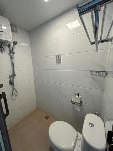 a white bathroom with a toilet and a sink at Kawoeng skyhouse BSD in Cilenggang