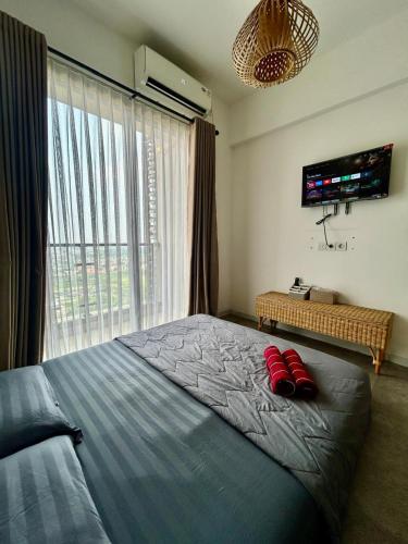 a bedroom with a large bed with red pillows on it at Kawoeng skyhouse BSD in Cilenggang