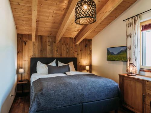 a bedroom with a bed in a room with wooden walls at Bernkogel Penthouse in Rauris