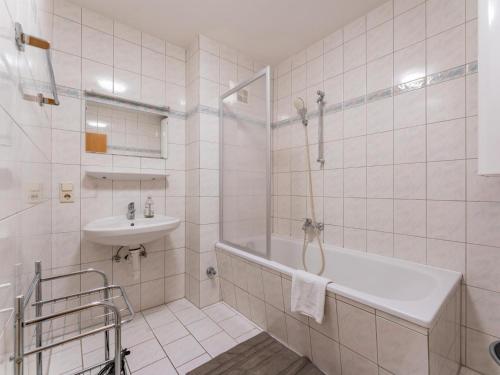 a white bathroom with a tub and a sink at Selmas in Zell am See