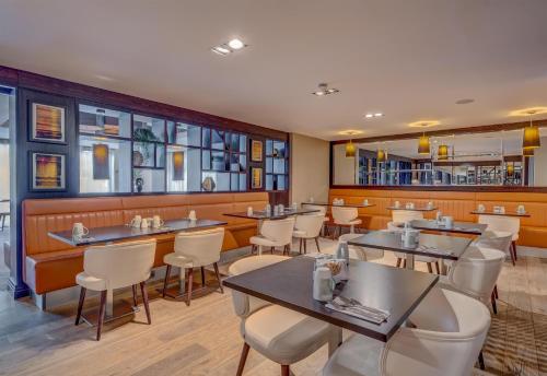 a restaurant with tables and chairs and a bar at DoubleTree by Hilton London Ealing in London