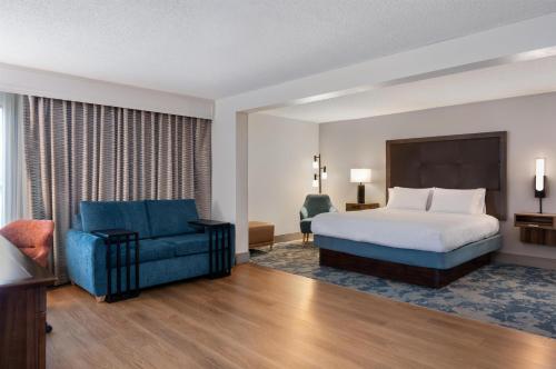 a hotel room with a bed and a blue chair at Hampton Inn South Hill in South Hill