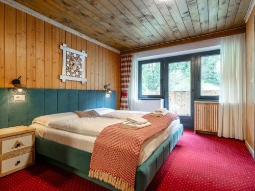 a bedroom with a bed in a room with wooden walls at Bergzeit Hollersbach L in Hollersbach im Pinzgau