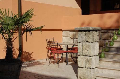 a table and chairs sitting next to a stone wall at Gut Zentgraf in Mörbisch am See