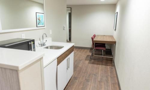 a white kitchen with a sink and a table at Hampton Inn Williamsport in Williamsport