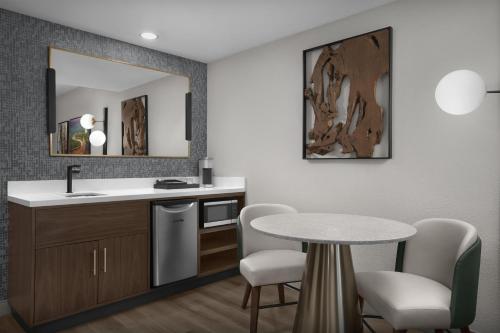 a bathroom with a sink and a table and chairs at Embassy Suites by Hilton Jackson North Ridgeland in Ridgeland