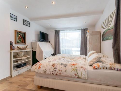 a bedroom with a bed and a tv and a window at Smaragdherz in Brandberg