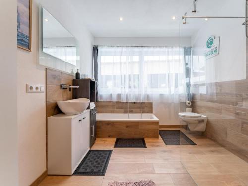 a bathroom with a tub and a sink and a toilet at Smaragdherz in Brandberg